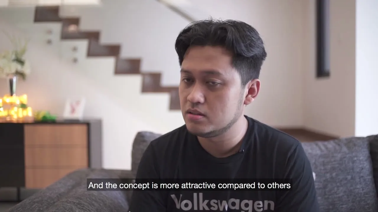 A OnePark homeowner seated on the sofa in his living room, the home’s open staircase behind him