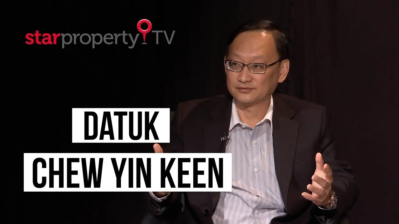 Datuk Chew Yin Keen in a dark suit gesturing during a StarProperty TV studio interview